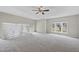 Living room with high ceilings, neutral carpet, lots of natural light from multiple windows, and a ceiling fan at 582 Ebenezer Church Rd, Coats, NC 27521