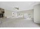 Spacious living room featuring a stone fireplace, neutral carpet, and lots of natural light from several windows at 582 Ebenezer Church Rd, Coats, NC 27521