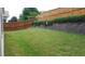 Backyard showing a grassy lawn, retaining wall and wood fence at 8504 Lasilla Way, Raleigh, NC 27616