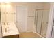 Bright primary bathroom featuring double sinks, a glass enclosed shower and tile floors at 8504 Lasilla Way, Raleigh, NC 27616