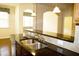 Kitchen bar featuring granite countertops, a stainless steel sink, and a view of the breakfast area at 8504 Lasilla Way, Raleigh, NC 27616