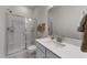 Bright bathroom featuring a glass-enclosed shower, white vanity, and neutral wall paint at 8620 Secreto Dr, Raleigh, NC 27606