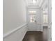 Bright foyer with white walls, dark hardwood floors, and a traditional white front door with glass inserts at 8620 Secreto Dr, Raleigh, NC 27606