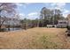 Expansive backyard with view of pond, mature trees, and covered back deck with railings at 902 Zion Church Rd, Sanford, NC 27330