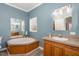 Bathroom featuring a soaking tub, a vanity, and large wall mirror at 902 Zion Church Rd, Sanford, NC 27330