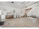 Large garage with plentiful storage, including white cabinets, shelving, refrigerator and stairs to loft at 902 Zion Church Rd, Sanford, NC 27330