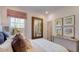 Bright bedroom showcases a plush bed with decorative pillows and serene view from the large window at 913 Thimbleweed Way, Wake Forest, NC 27587