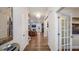 Bright hallway with hardwood floors leading to living area with fireplace, and kitchen with stainless appliances at 913 Thimbleweed Way, Wake Forest, NC 27587