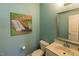 Powder bathroom showcasing a sink, toilet, mirror and a beautiful waterfall art piece at 100 Pinto Saddle Ct, Garner, NC 27529