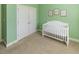 Bedroom with a white crib, closet, and turtle-themed wall art, creating a calming atmosphere at 100 Pinto Saddle Ct, Garner, NC 27529
