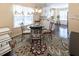 Cozy dining area with a glass table, chandelier, colorful rug and white cabinets at 100 Pinto Saddle Ct, Garner, NC 27529