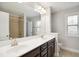 Spacious bathroom featuring dual sinks, and a bath tub with shower, and a window to let in natural light at 1015 Rexburg Dr, Cary, NC 27513