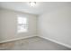 Neutral carpeted bedroom with one window, base trim throughout, and neutral paint at 1015 Rexburg Dr, Cary, NC 27513