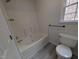 Bathroom features a tub with white surround, toilet, and window at 1032 Holly Pointe Dr, Wendell, NC 27591