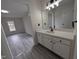 Bathroom with white vanity, modern lighting, and view to bedroom at 1032 Holly Pointe Dr, Wendell, NC 27591