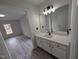 Bathroom with white vanity, modern lighting, and view to bedroom at 1032 Holly Pointe Dr, Wendell, NC 27591