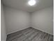 Simple bedroom with gray plank flooring, white walls, and overhead lighting at 1032 Holly Pointe Dr, Wendell, NC 27591