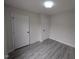 Clean bedroom featuring updated flooring, modern lighting, and closet space at 1032 Holly Pointe Dr, Wendell, NC 27591