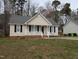 Charming single-story home with neutral siding, black shutters, and a cozy, white picket front porch at 1032 Holly Pointe Dr, Wendell, NC 27591