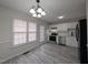 Bright kitchen featuring stainless steel appliances, white cabinets and backsplash, and modern light fixture at 1032 Holly Pointe Dr, Wendell, NC 27591