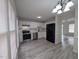 Bright kitchen featuring stainless steel appliances, white cabinets and backsplash, and modern light fixture at 1032 Holly Pointe Dr, Wendell, NC 27591