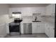 Bright kitchen featuring stainless steel appliances, white cabinets and backsplash, and gray wood-look floors at 1032 Holly Pointe Dr, Wendell, NC 27591