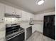 Bright kitchen featuring stainless steel appliances, white cabinets and backsplash, and gray wood-look floors at 1032 Holly Pointe Dr, Wendell, NC 27591