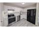 Kitchen featuring stainless steel appliances, white cabinets and backsplash, and gray wood-look floors at 1032 Holly Pointe Dr, Wendell, NC 27591