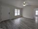 Bright living room features vaulted ceilings, ceiling fan, and newly installed gray wood flooring at 1032 Holly Pointe Dr, Wendell, NC 27591