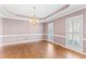 Formal dining room with hardwood floors, chandelier, and windows with shutter blinds at 104 Glenmore Rd, Cary, NC 27519