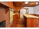 Kitchen has brick fireplace, wood cabinets, center island and tile floor at 104 Parker St, Oxford, NC 27565