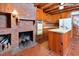 Country kitchen features a brick fireplace, wood cabinets, and a center island with sink at 104 Parker St, Oxford, NC 27565