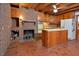 Kitchen featuring brick fireplace, wood cabinets, center island and tile flooring at 104 Parker St, Oxford, NC 27565