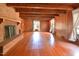 Spacious living room with a brick fireplace, wood floors, and exposed wood beams at 104 Parker St, Oxford, NC 27565