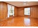 The living room features wood floors, a ceiling fan, wood paneling, and natural light from two windows at 104 Parker St, Oxford, NC 27565