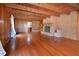 Large living room featuring exposed beams, hardwood floors, and a cozy brick fireplace at 104 Parker St, Oxford, NC 27565