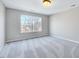 Bright bedroom with large window and neutral gray walls and carpet at 105 Presley Snow Ct, Holly Springs, NC 27540