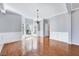 Elegant dining area showcasing hardwood floors, wainscoting, a bay window, and a modern chandelier at 105 Presley Snow Ct, Holly Springs, NC 27540
