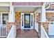 Inviting front porch featuring white railings, brick accents, and a stylish front door with sidelights at 105 Presley Snow Ct, Holly Springs, NC 27540