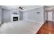 Spacious living room featuring a fireplace, ceiling fan, and neutral carpet at 105 Presley Snow Ct, Holly Springs, NC 27540