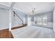 Inviting living room featuring neutral carpeting, wainscoting, and a staircase leading to the second floor at 105 Presley Snow Ct, Holly Springs, NC 27540