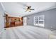 Open-concept living space with kitchen view, ceiling fan and large window at 105 Presley Snow Ct, Holly Springs, NC 27540