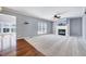 Large living room with fireplace, ceiling fan, and seamless floor transition at 105 Presley Snow Ct, Holly Springs, NC 27540