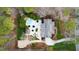 An aerial view of a beautiful home surrounded by lush trees, featuring a pool, patio, and circular driveway at 106 Woodkirk Ln, Chapel Hill, NC 27514