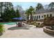 Expansive backyard with a sparkling pool, elegant patio furniture, fire pit, and manicured landscaping at 106 Woodkirk Ln, Chapel Hill, NC 27514