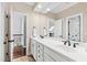 Bathroom featuring double sinks, white cabinets, tile flooring, and a large mirror at 106 Woodkirk Ln, Chapel Hill, NC 27514