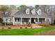 Charming home featuring a brick walkway leading to a column-lined front porch with rocking chairs at 106 Woodkirk Ln, Chapel Hill, NC 27514