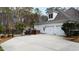 Spacious home exterior featuring a three-car garage, fenced yard, and lush trees, offering privacy and convenience at 106 Woodkirk Ln, Chapel Hill, NC 27514