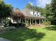 Beautiful home with well-manicured lawn and landscaping, complete with a brick porch and rocking chairs at 106 Woodkirk Ln, Chapel Hill, NC 27514