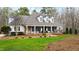 A charming home boasting a covered front porch, lush green lawn, and mature trees at 106 Woodkirk Ln, Chapel Hill, NC 27514